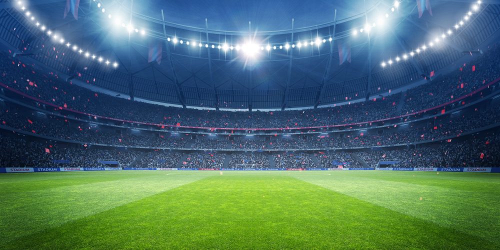 Soccer stadium at night with bright lights showcasing a bright green field